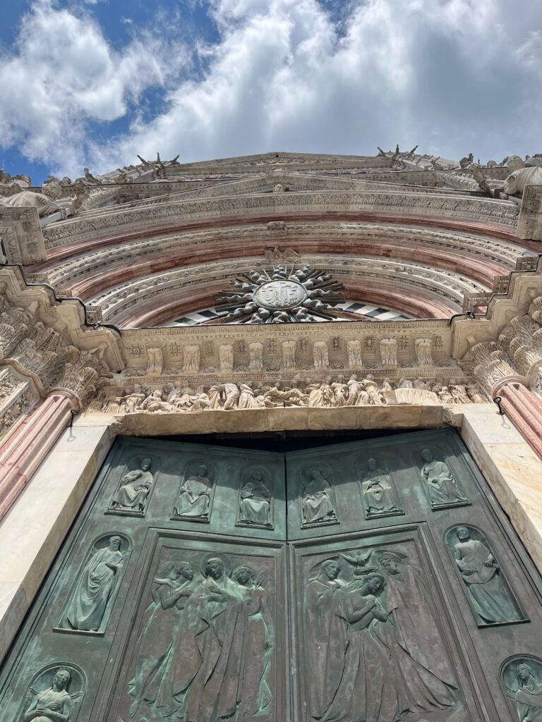 De bronzen deuren met de marmeren bogen van de ingang