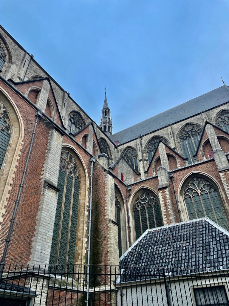 De mooie steegjes en hofjes van Leiden: De Hooglandse Kerk met de rode sterkappelen op de voorgrond en de hoge, grijze transeptarmen en het koor er achter